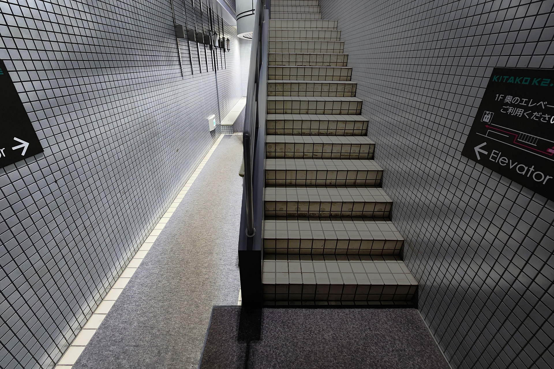 向かって左手に通路、右手に上階へ伸びる階段があります