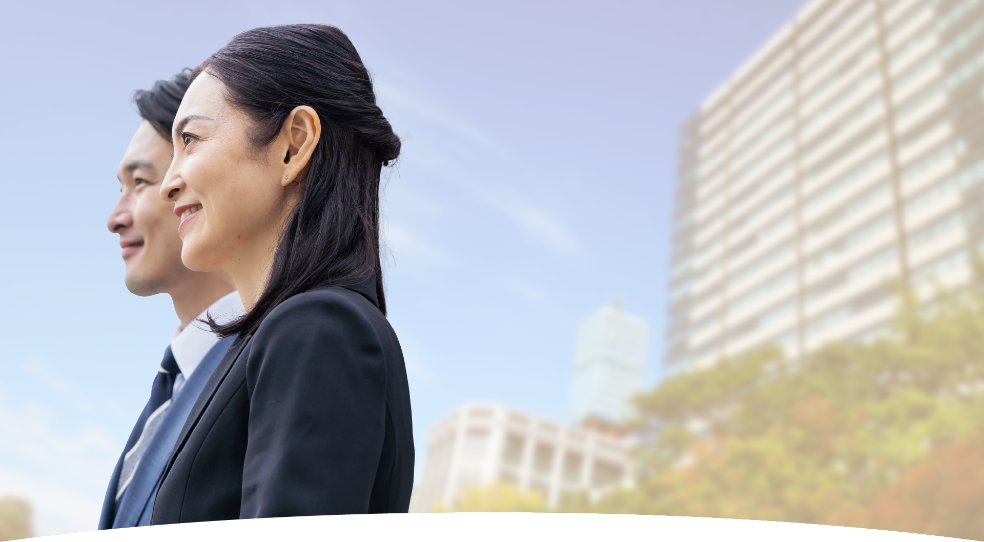 隣り合い、空を見上げる男女のビジネスマンの画像